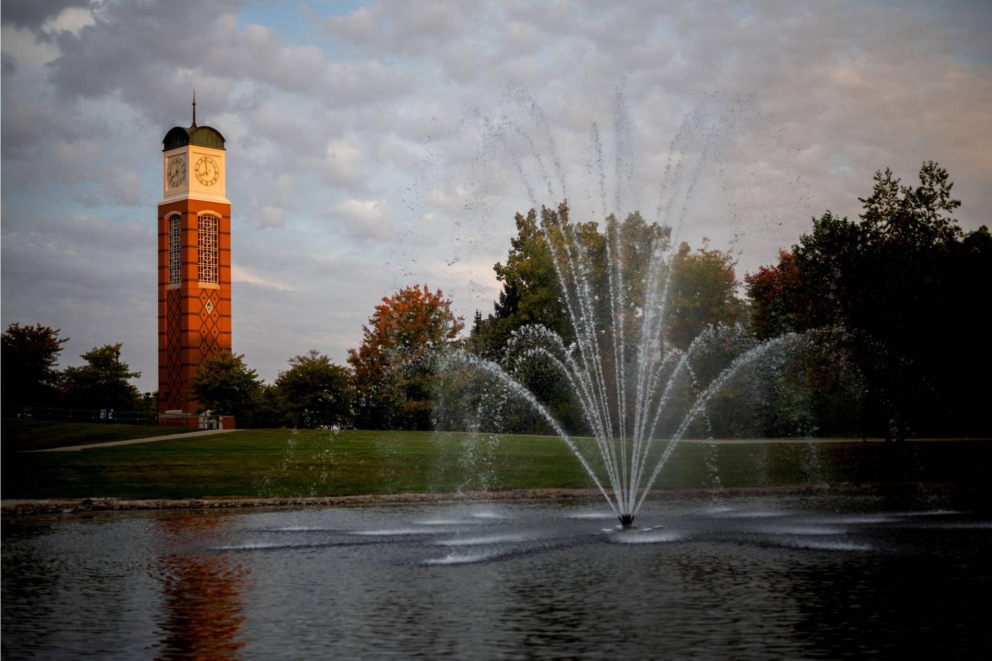Image of pond and fountain with GVSU clock tower in the background